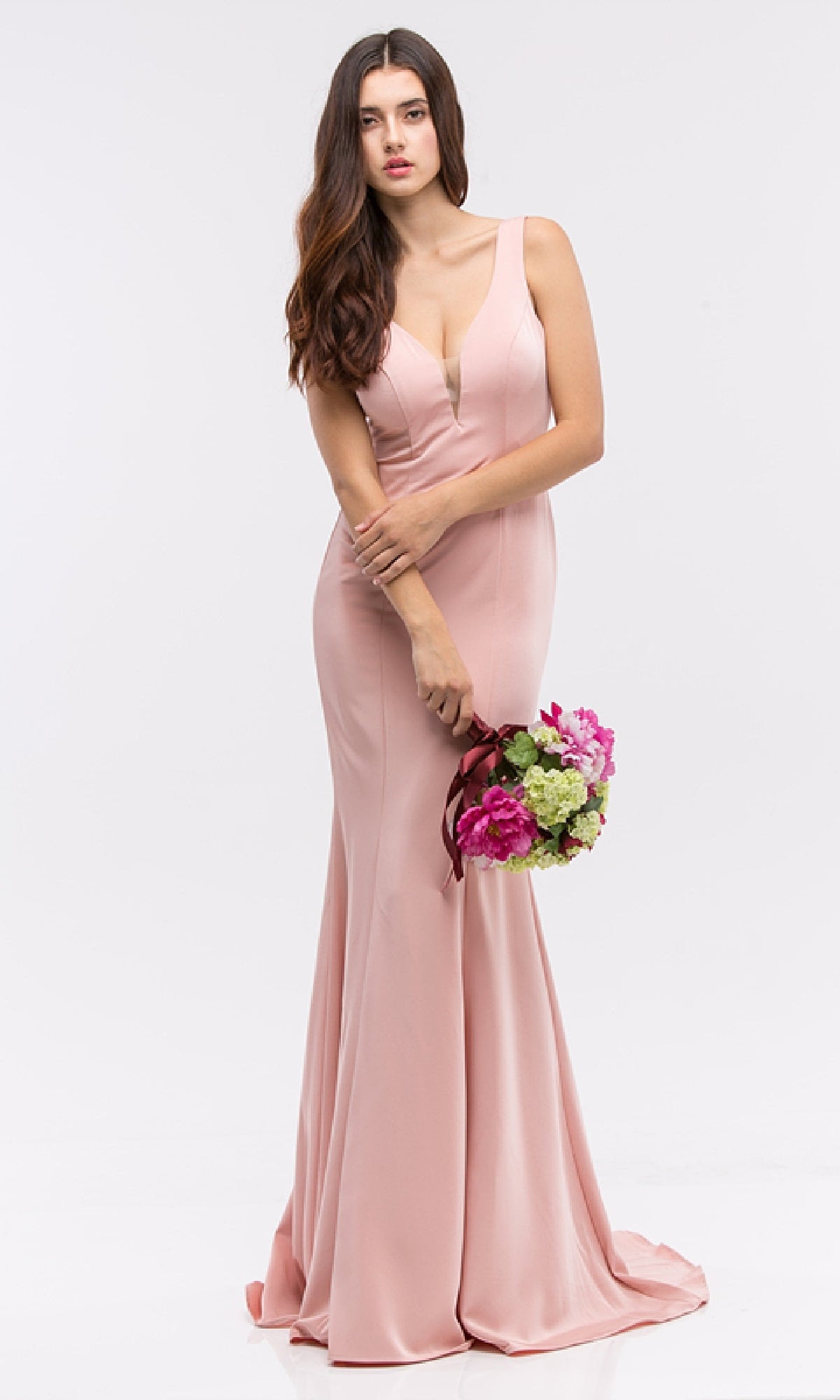 A woman wears the Classic Long V-Neck Satin Prom Dress: Eureka 6010 in blush pink, holding a bouquet of pink and green flowers against a plain white background.